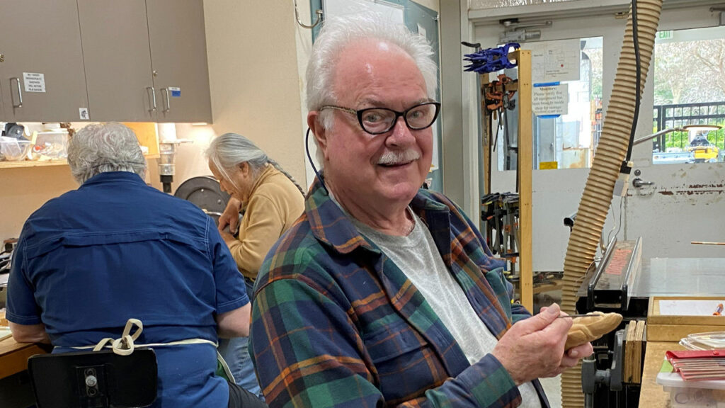 Gary is polishing the carved Santa before painting it.