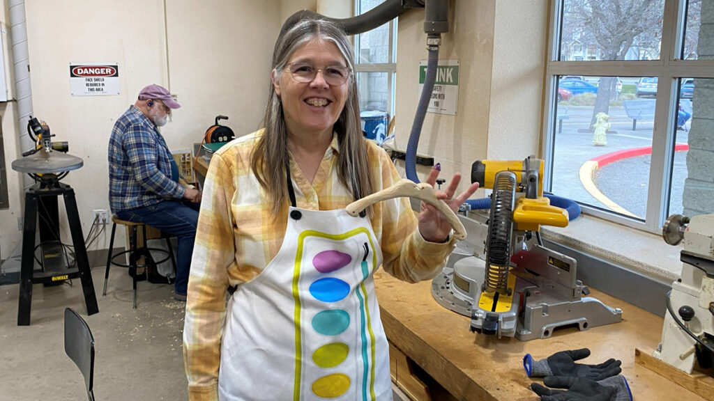 Jenifer is carving a small crossbow.