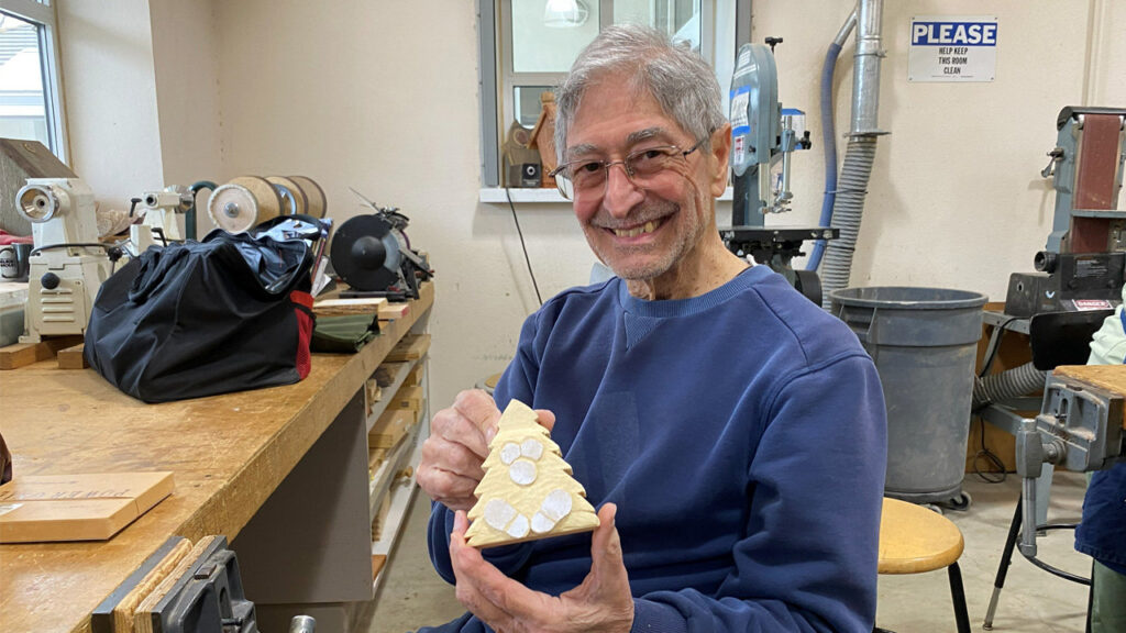Mike is carving a Christmas tree ornament.