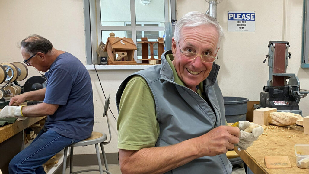 Rich is carving a small wooden item.
